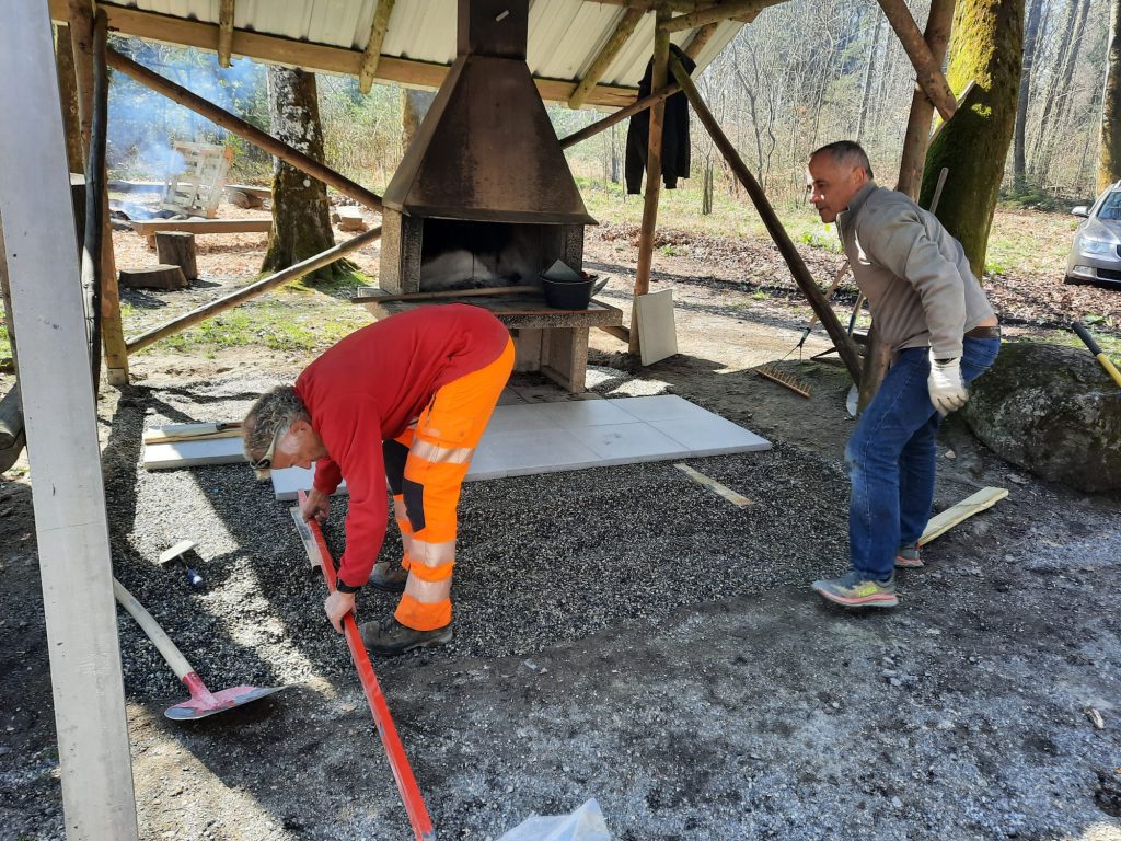 Deux bénévoles du comité posent le nouveau dallage du grill au Refuge de Reverolle